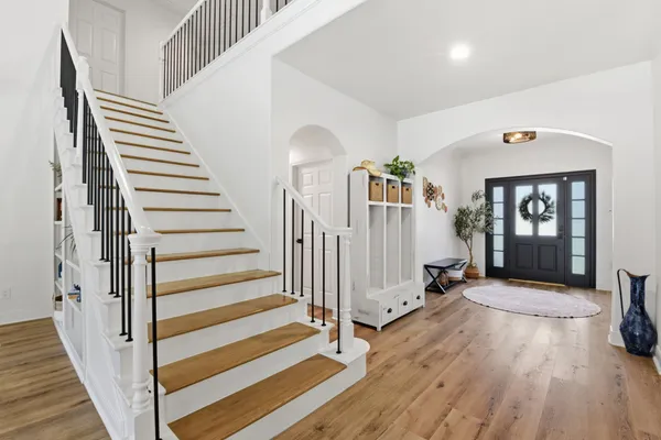 a view of a hallway with wooden floor and stairs