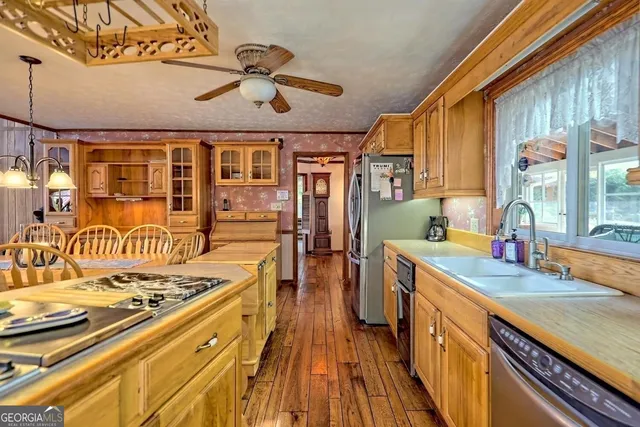 a kitchen with stainless steel appliances granite countertop a lot of counter space and wooden floors