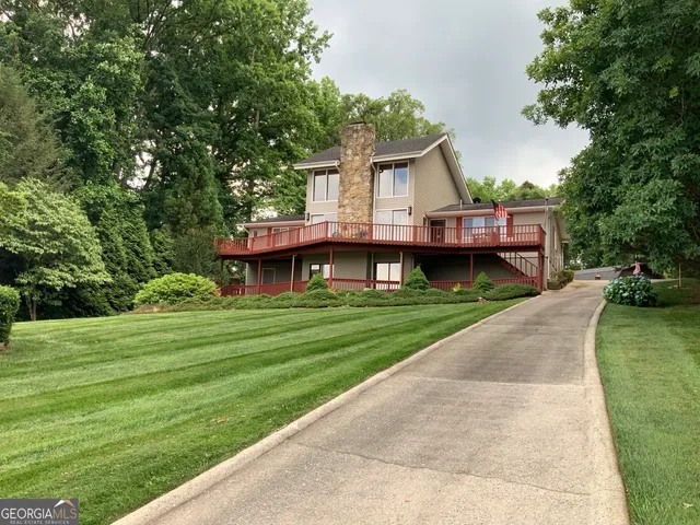 a front view of a house with a yard and trees