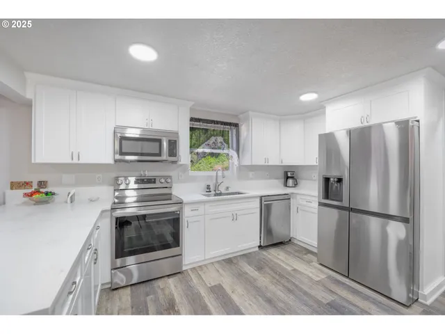 a kitchen with a refrigerator a stove top oven a sink and dishwasher