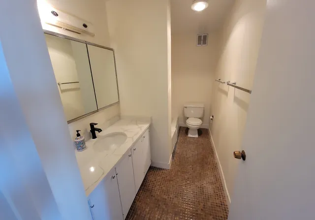 a bathroom with a sink a toilet and a mirror