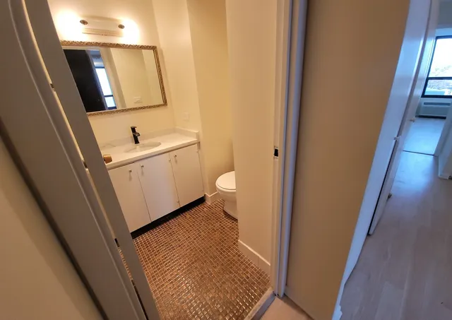 a bathroom with a sink and mirror with toilet