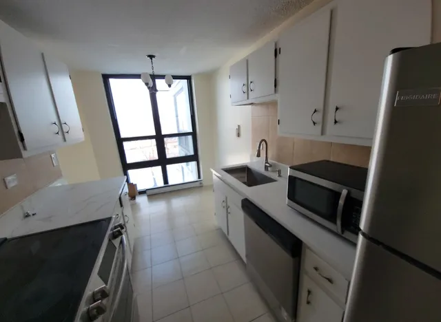 a kitchen with stainless steel appliances a stove microwave and a refrigerator