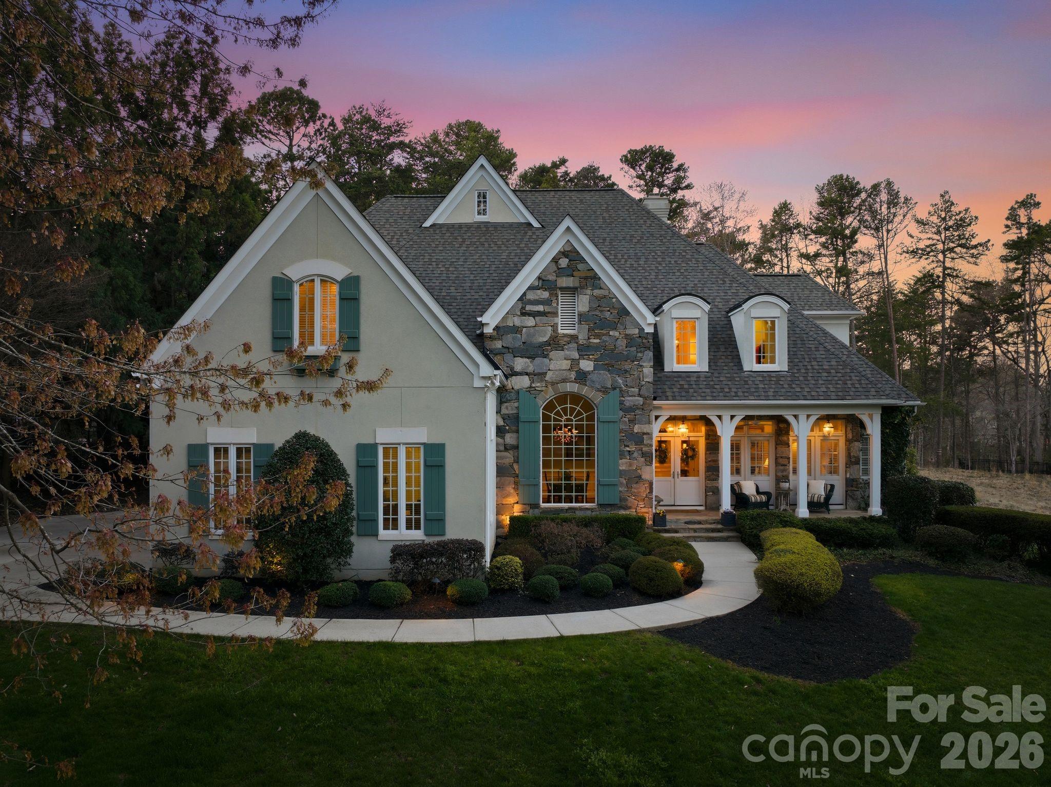 a front view of a house with a garden and plants
