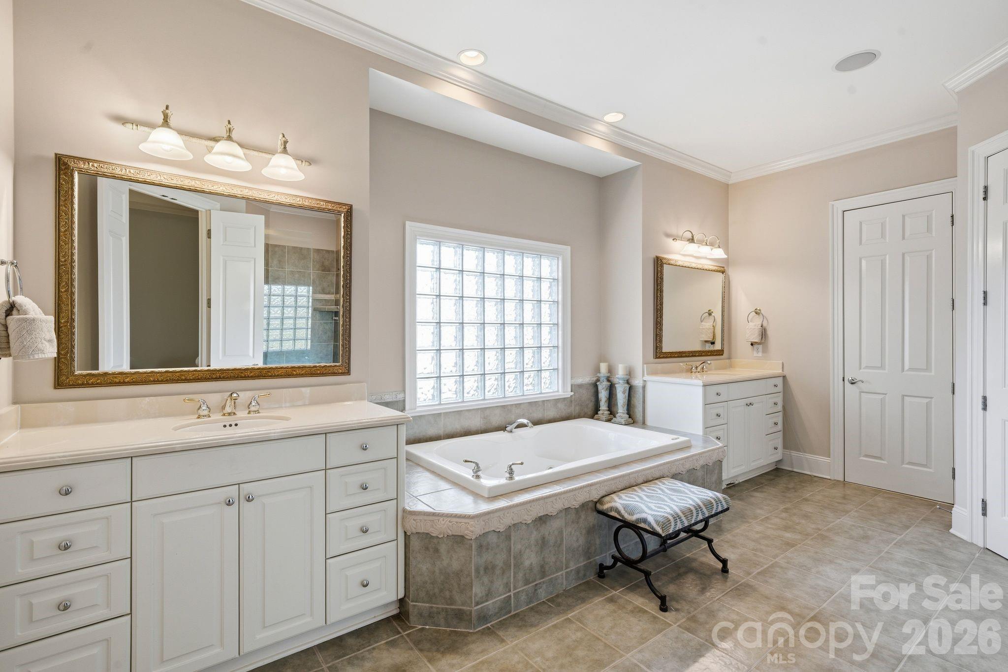185 Quaker Road Mooresville, NC 28117 - Photo 24 of 43 a spacious bathroom with a granite countertop sink mirror and a bathtub