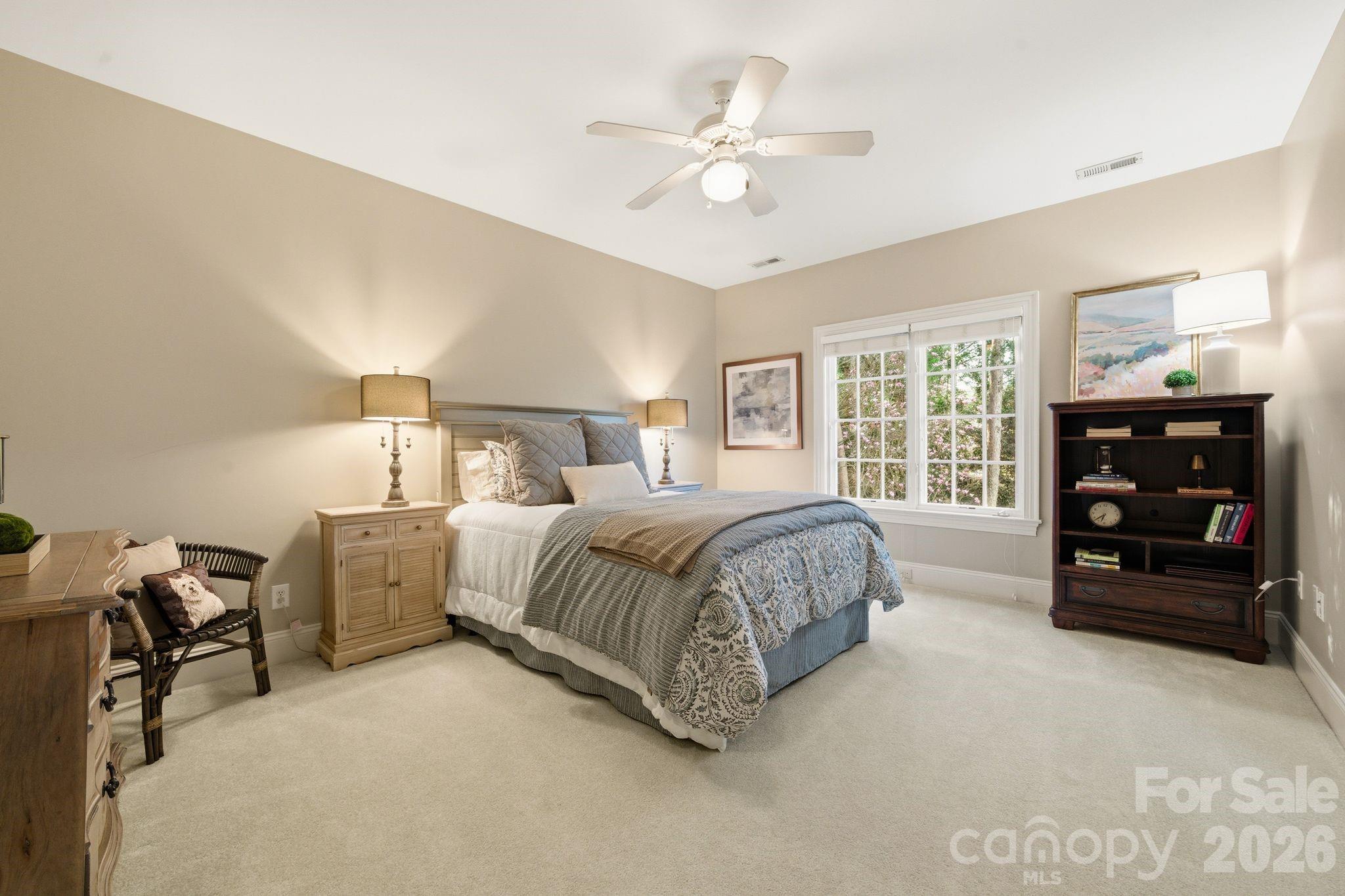 185 Quaker Road Mooresville, NC 28117 - Photo 27 of 43 a spacious bedroom with a bed a dresser and a chandelier