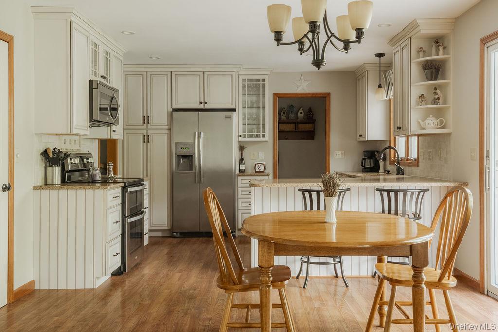4 Echo Valley Road Red Hook, NY 12571 - Photo 5 of 33 a kitchen with stainless steel appliances granite countertop a dining table chairs refrigerator and sink