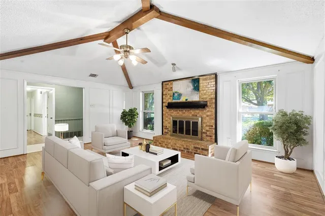 a living room with fireplace furniture and a large window