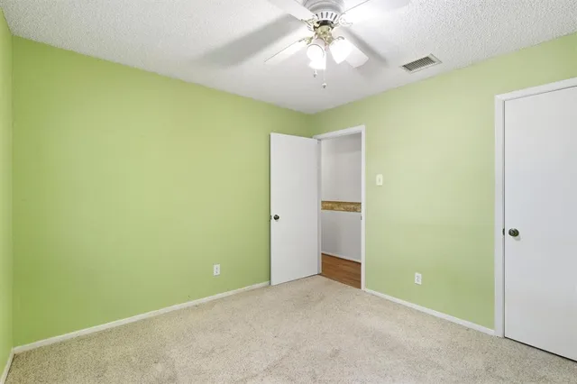 an empty room with a chandelier fan and a chandelier fan