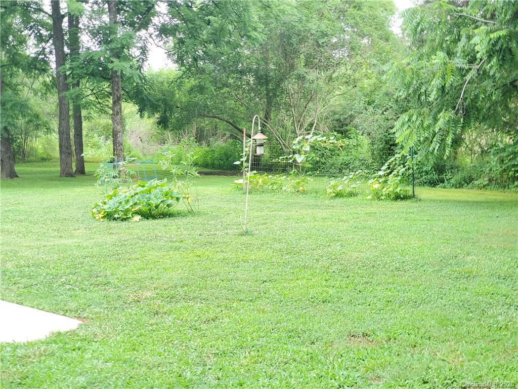 483 Freeman Road Forest City, NC 28043 - Photo 18 of 21 a backyard of a house with plants and large trees