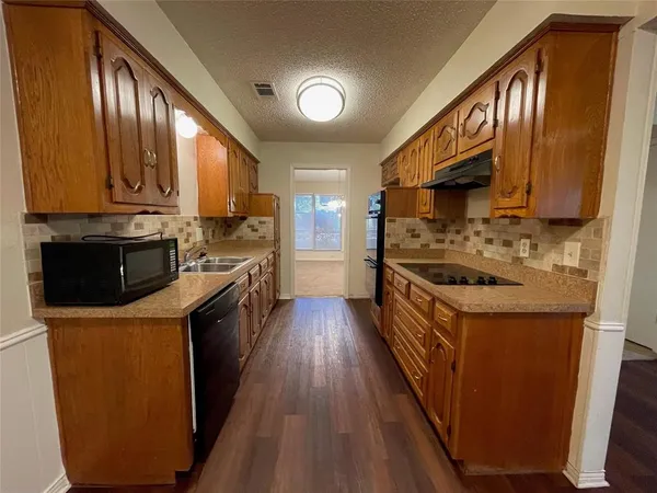 a kitchen with stainless steel appliances granite countertop a stove a sink dishwasher and a refrigerator