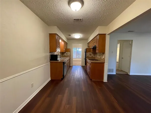 a kitchen with stainless steel appliances a refrigerator and wooden floor