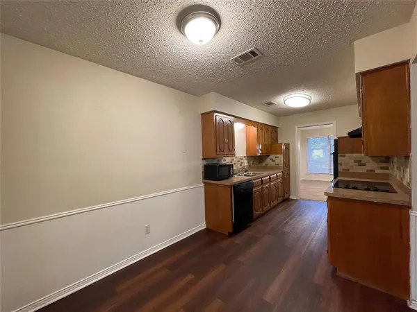 a kitchen with a refrigerator and a stove top oven