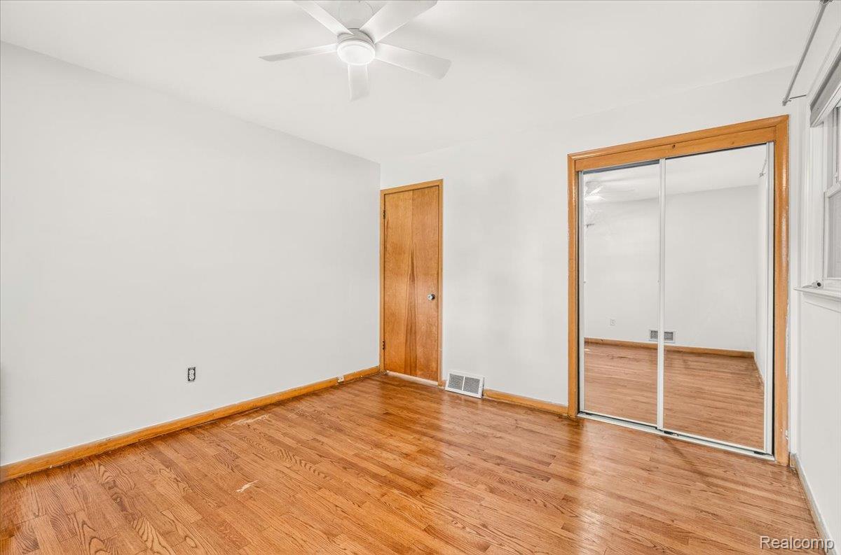 11802 Columbia Street Redford, MI 48239 - Photo 21 of 39 Bedroom 3 with Original Hardwood Floors in good condition, Vinyl Replacement Windows, a New Ceiling Fan, and Mirrored Closet Doors.