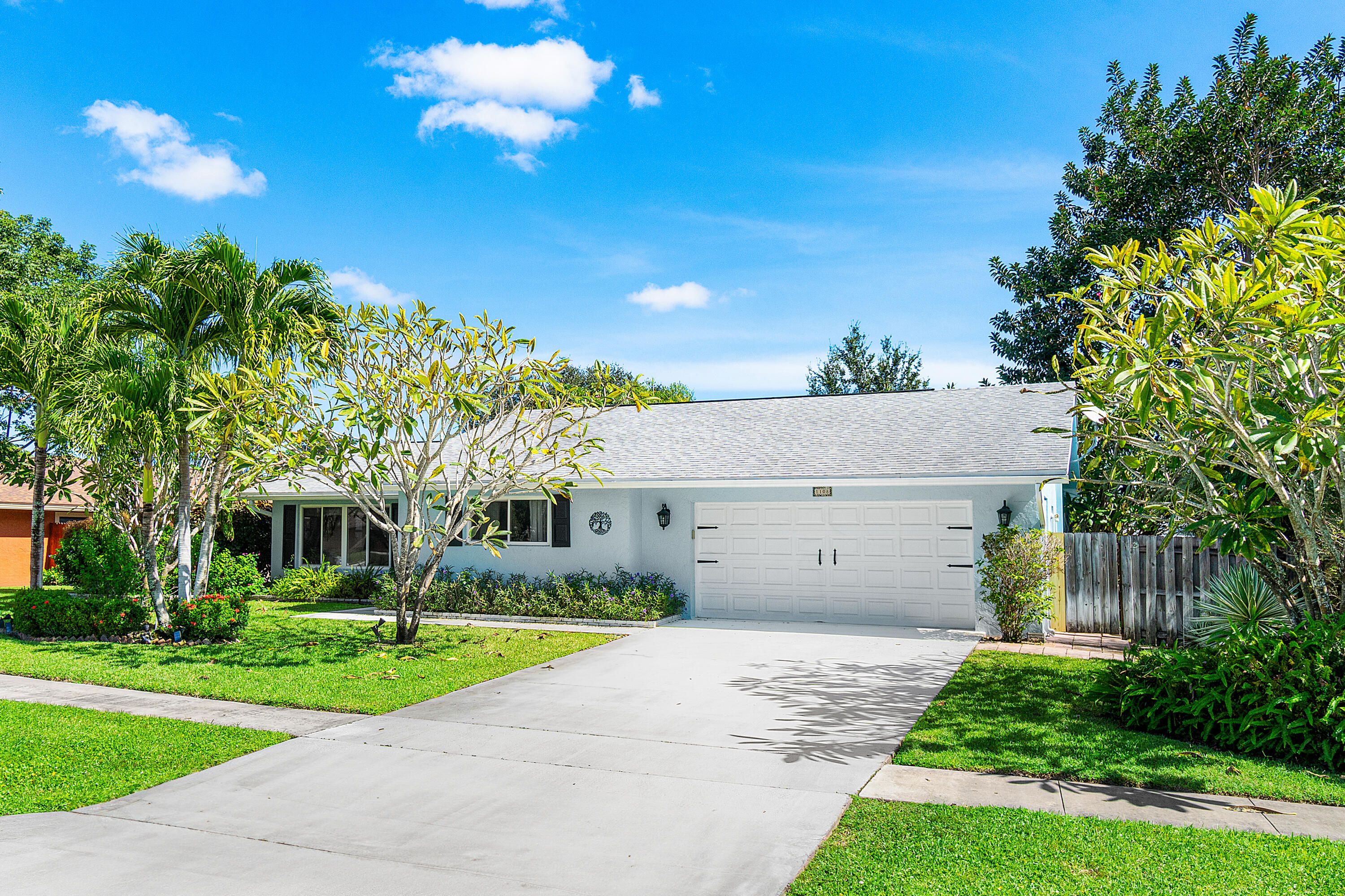 1108 Petrel Road Wellington, FL 33414 - Photo 2 of 46 a front view of a house with a garden and trees