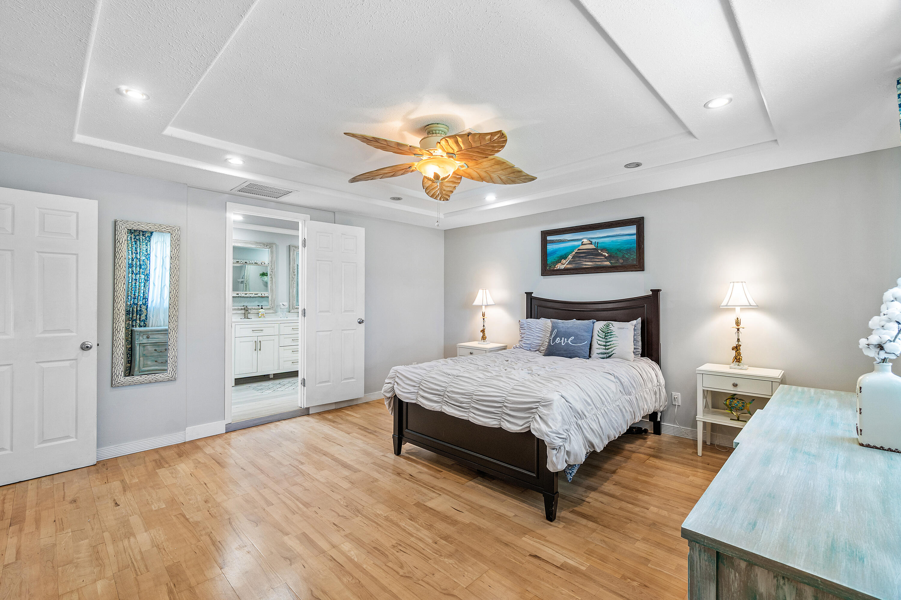1108 Petrel Road Wellington, FL 33414 - Photo 22 of 46 a spacious bedroom with a bed and a chandelier