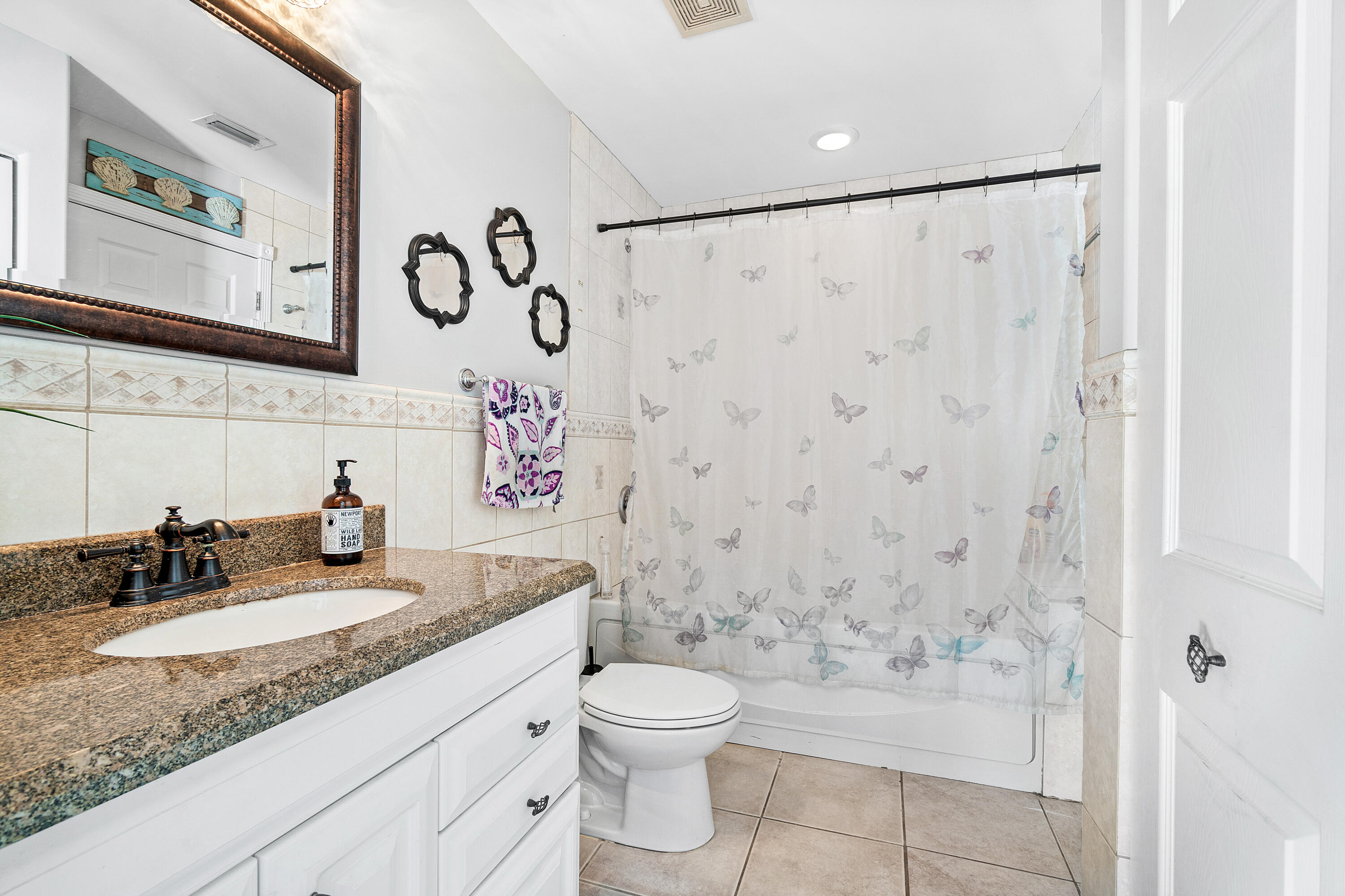 1108 Petrel Road Wellington, FL 33414 - Photo 34 of 46 a bathroom with a granite countertop sink a toilet and a shower