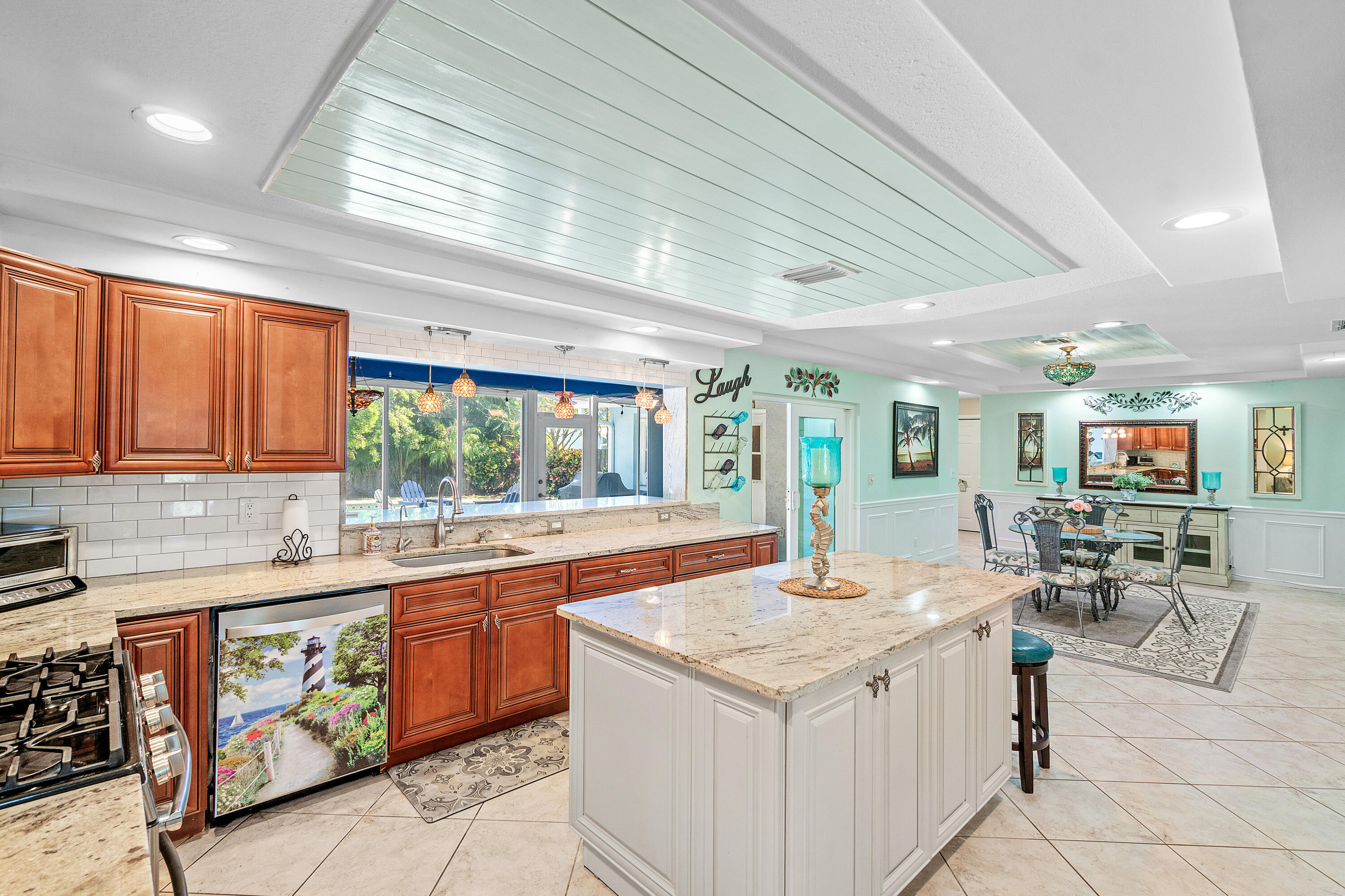 1108 Petrel Road Wellington, FL 33414 - Photo 10 of 46 a kitchen with a stove a sink a dining table and chairs