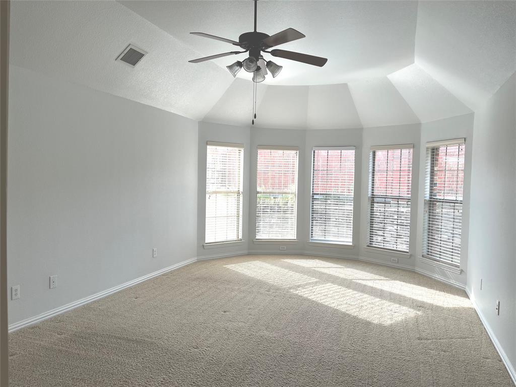 4101 White Porch Road Plano, TX 75024 - Photo 10 of 18 Master bedroom featuring a vaulted ceiling with a ceiling fan, a bay window with five individual windows, and light-toned carpeting.