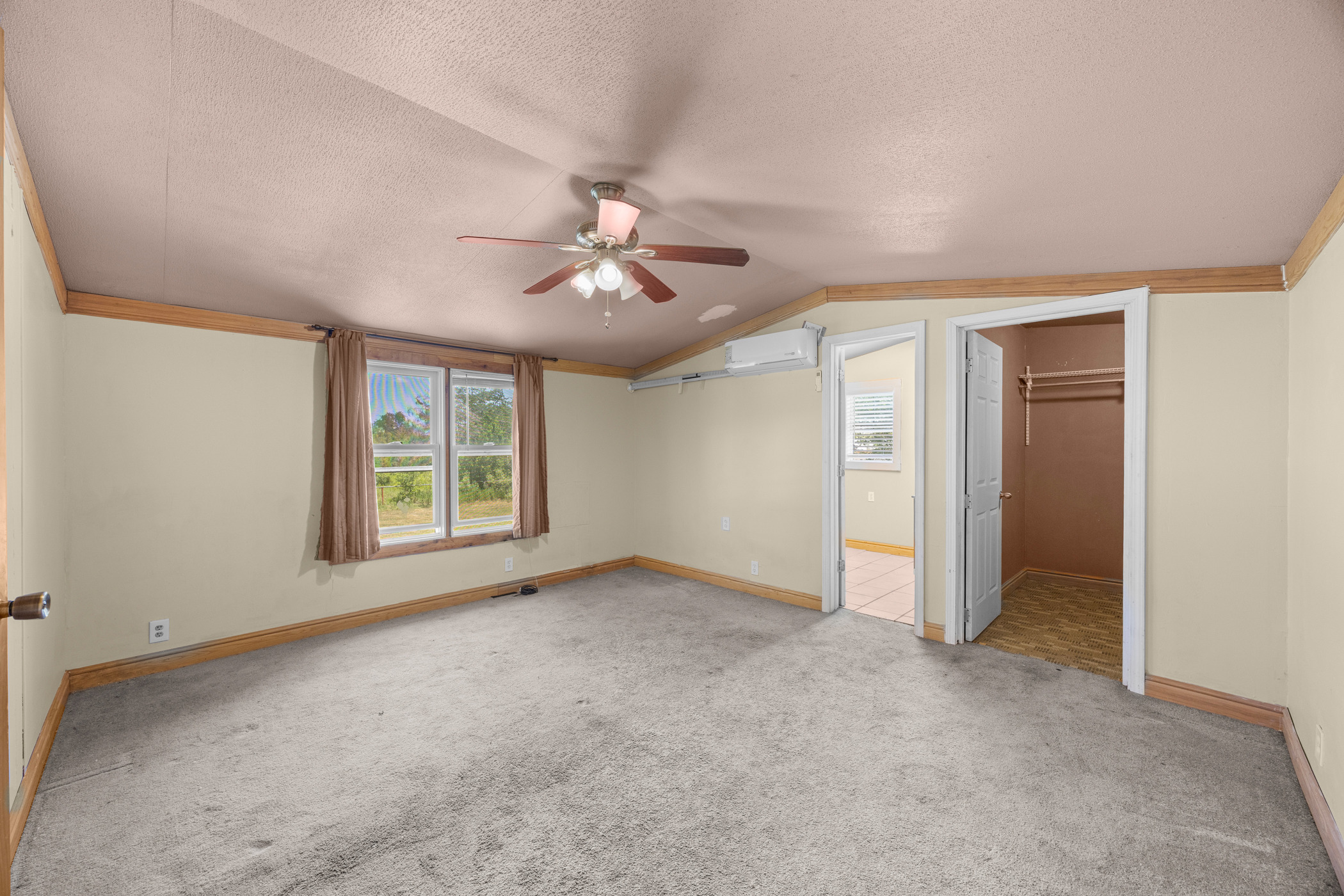 147 Community Center Road Rosanky, TX 78953 - Photo 13 of 33 Unfurnished bedroom featuring a spacious closet, light colored carpet, and ceiling fan