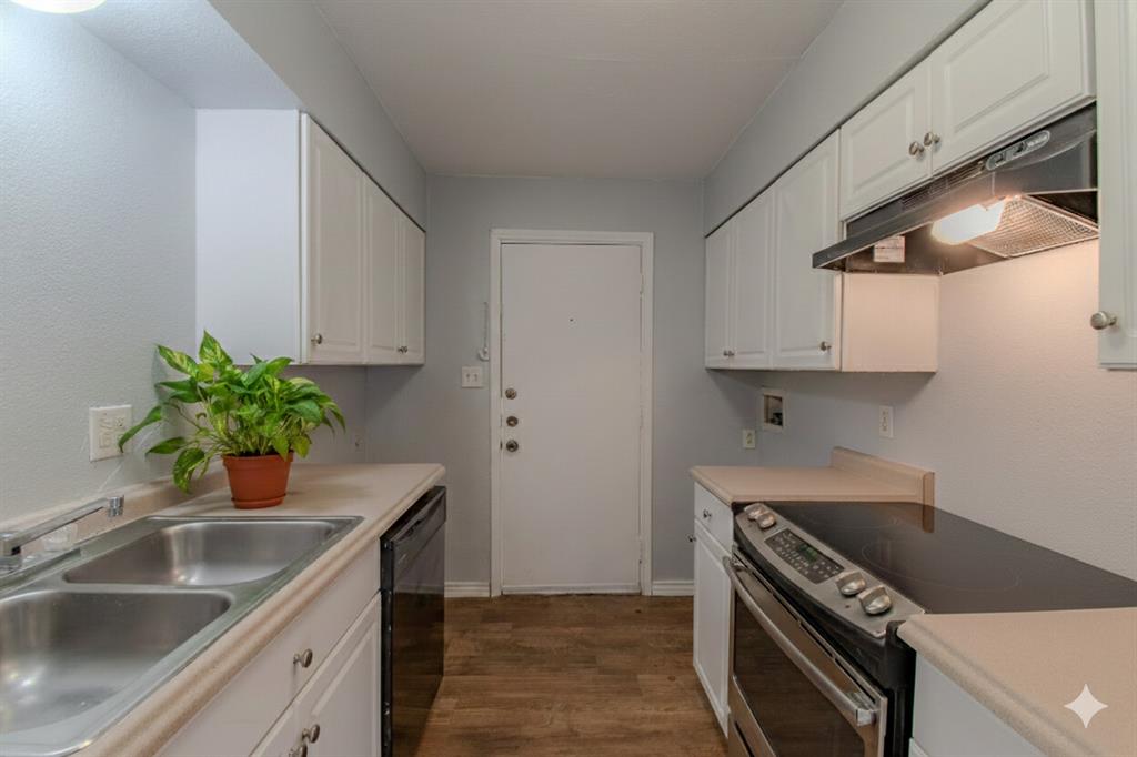 100 Uhland Road, Unit 3 San Marcos, TX 78666 - Photo 11 of 24 Kitchen with stainless steel range with electric cooktop, white cabinetry, light countertops, and dark wood-style flooring