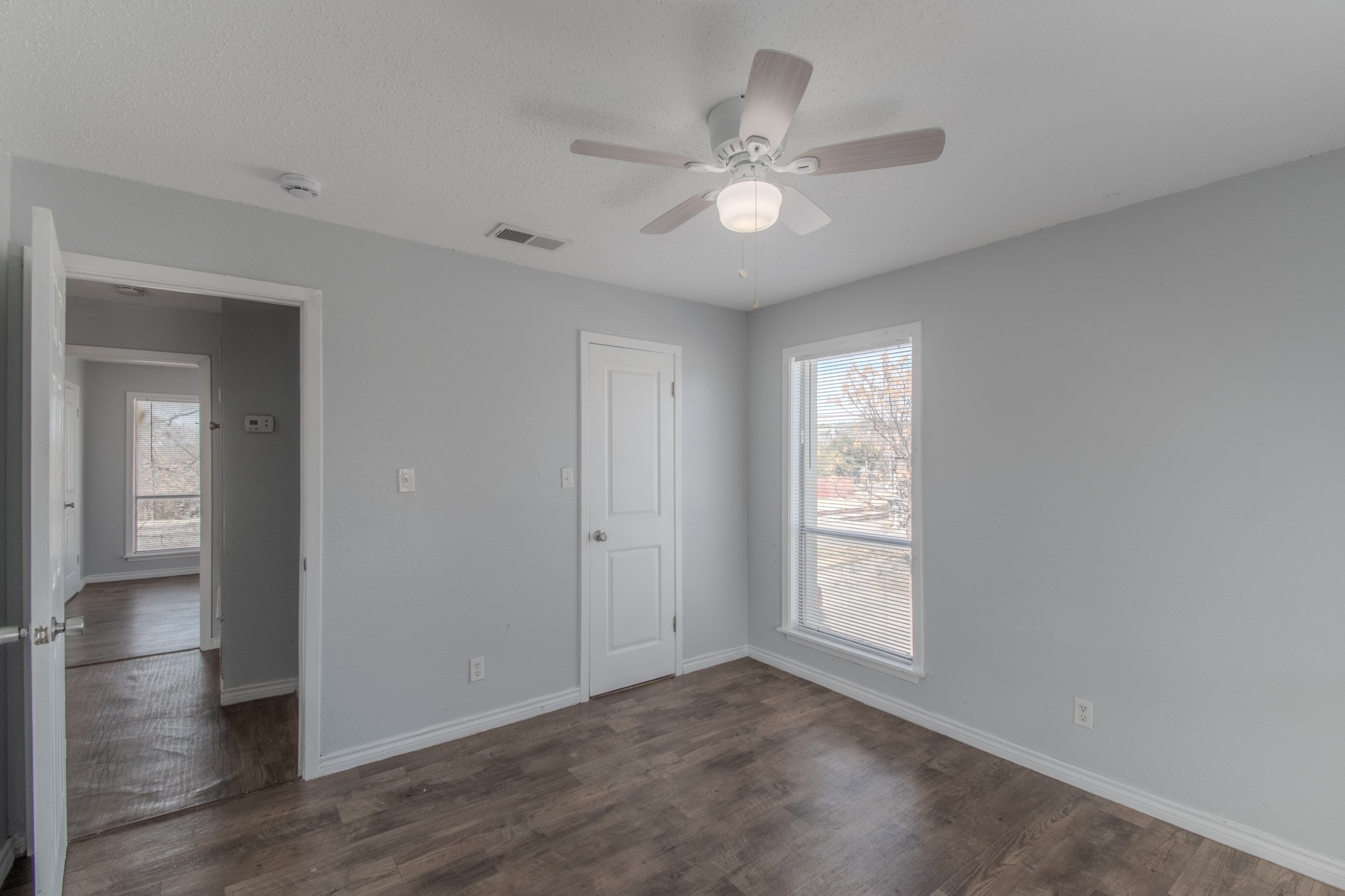 100 Uhland Road, Unit 3 San Marcos, TX 78666 - Photo 18 of 24 Unfurnished bedroom featuring dark wood finished floors, ceiling fan, and a closet