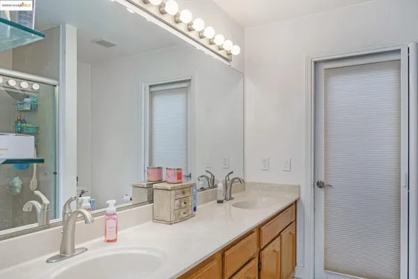 a bathroom with double vanity sinks and a mirror