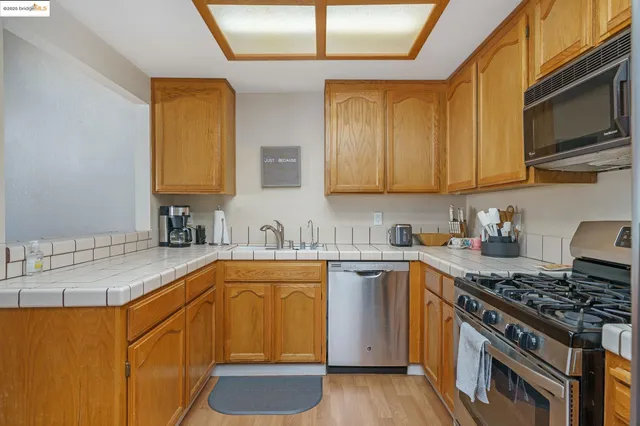 a kitchen with stainless steel appliances granite countertop a sink stove and cabinets