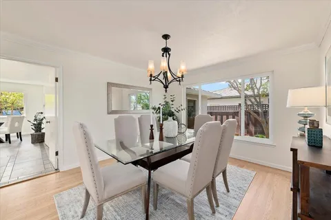 a dining room with furniture potted plants and wooden floor