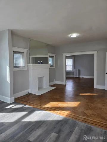 an empty room with floor to ceiling windows and fireplace