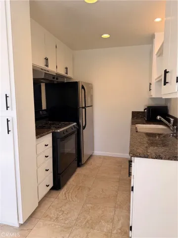 a kitchen with stainless steel appliances a stove a microwave and white cabinets