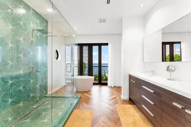 a spacious bathroom with a double vanity sink a large mirror and shower