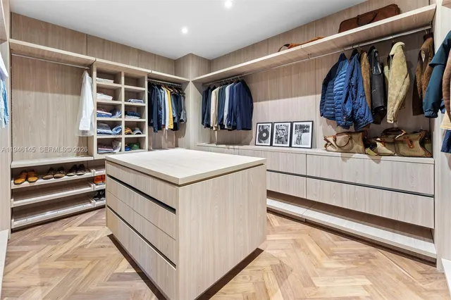 a view of walk in closet with clothes and shoes