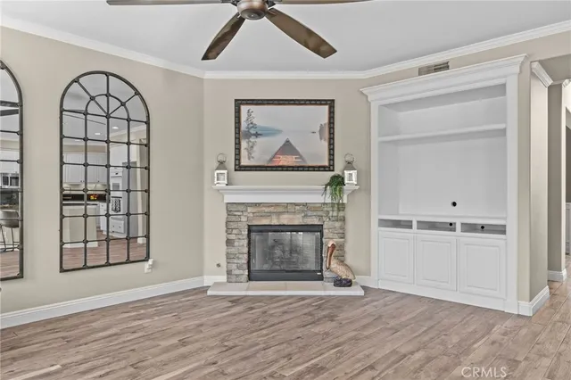 an empty room with windows fireplace and wooden floor