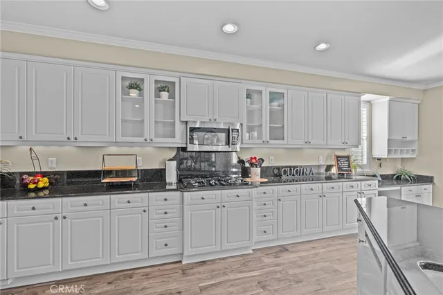 a kitchen with granite countertop white cabinets and sink