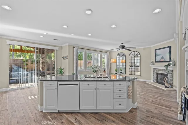 a kitchen with stainless steel appliances granite countertop a sink and cabinets with wooden floor