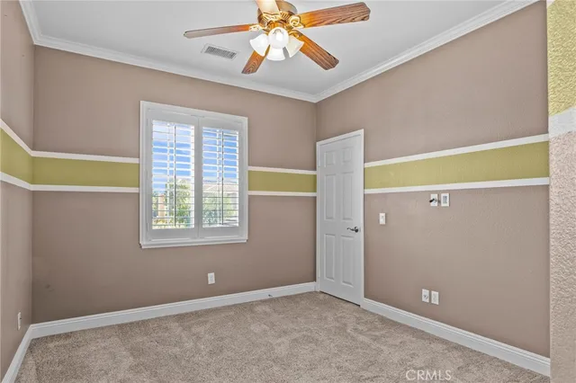 a view of an empty room with window and a ceiling fan