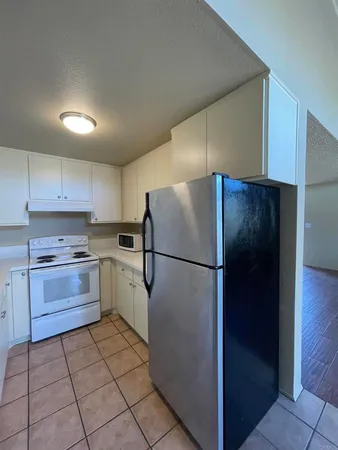 a kitchen with a refrigerator and a stove top oven