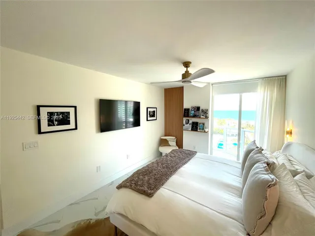 a spacious bedroom with a bed and a flat screen tv