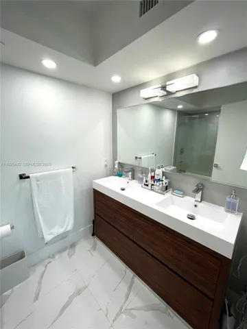 a bathroom with a double vanity sink a mirror and a shower