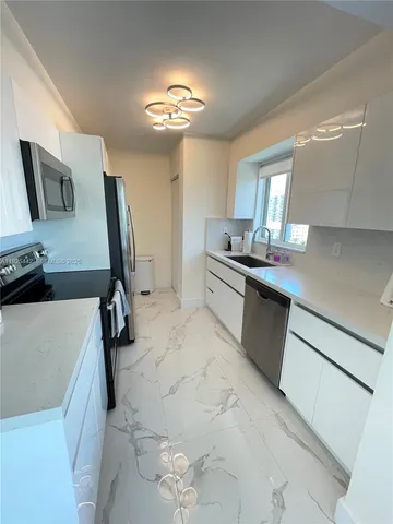 a kitchen with a sink appliances and cabinets