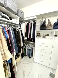 a view of walk in closet with clothes and shoes