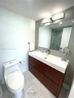 a bathroom with a toilet a sink and mirror