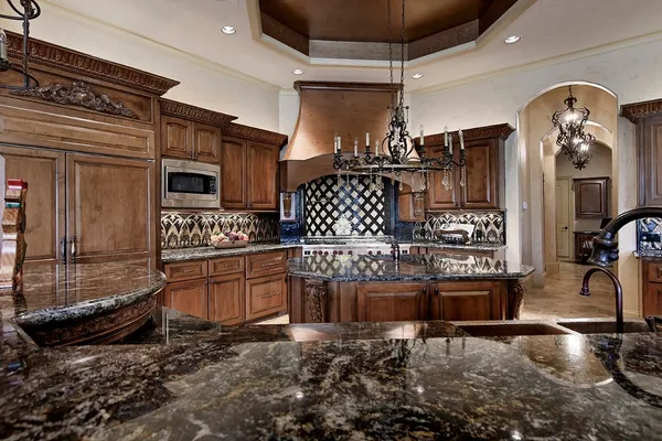 a kitchen with granite countertop a sink a stove and cabinets