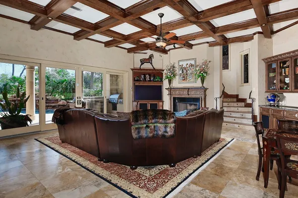 a living room with furniture a fireplace and a ceiling fan