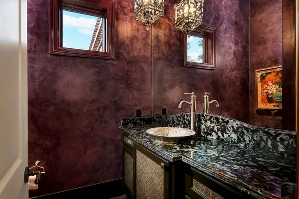 a bathroom with a granite countertop sink a mirror and vanity