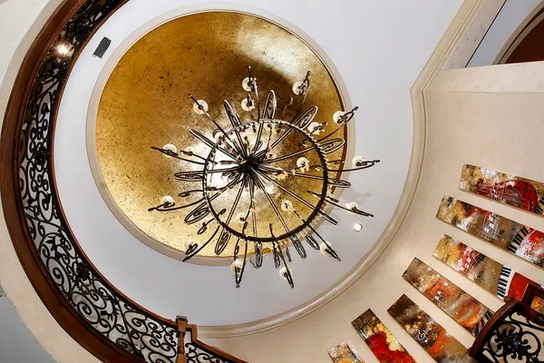 a living room with a chandelier and kitchen view