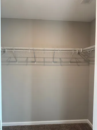 an empty room with closet and a chandelier fan