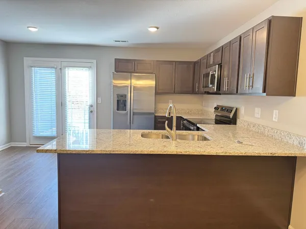 an empty room with wooden floor and chandelier