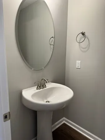 a white toilet sitting in a bathroom next to a wooden floor